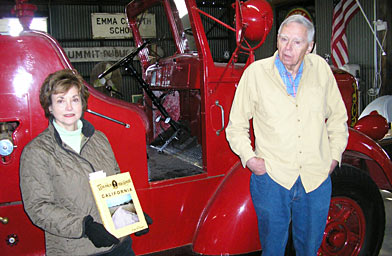 
                    Slide 3
Marie Abbott holds a book about the Lincoln Highway, near the Model T fire engine that Bill Junk takes care of in his role as curator of the Lincoln Highway Museum in the Duarte Garage.
                                            (Pat Loeb)
                                        