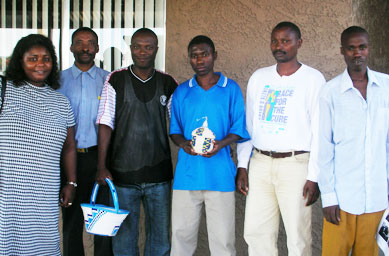 Jeanne stands with new Burundian refugees outside the apartment complex in Phoenix where many of the Burundian families have been re-settled. The men are holding the Burundian baskets they brought with them from Burundi.
(Ann Heppermann and Kara Oehler)