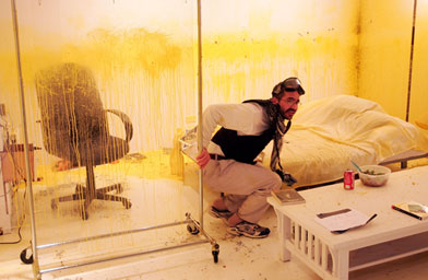 Iraqi born artist Wafaa Bilal keeps low to prevent from getting shot by paintballs in his "Domestic Tension" exhibit at the Flatfile Galleries Chicago.
(Scott Olson / Getty Images)