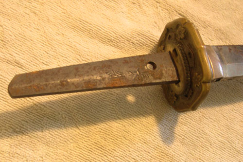 
                    After we finally got the sword handle off, the signature of the sword maker was revealed.  "Nagatsuna."
                                            (Krissy Clark)
                                        