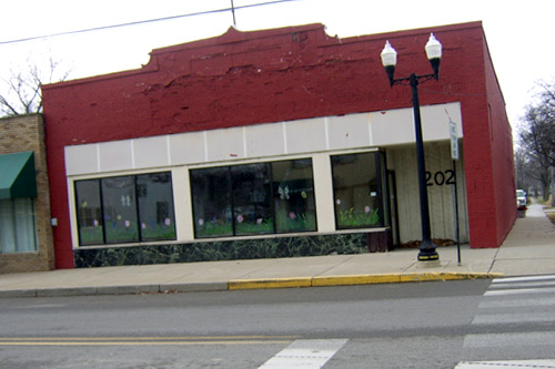 In 2005, this building was the Ole Gray Nash Auction House, where a number of Ku Klux Klan robes and Klan paraphernalia were auctioned off. Auctioneer Gary Gray told a New York Times reporter that he wasn't racist, but that "this is history, and we can't forget that it happened." The auction was originally scheduled to take place on the Martin Luther King Holiday weekend, but was postponed following widespread outrage. Today the building is empty, and flowers have been painted in the windows.
(Desiree Cooper)
