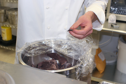 Colin Gasko holds the raw chocolate he uses to create the confections sold by his company, Rogue Chocolatier.
(Josh Sarantitis)