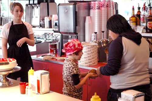 
                    Schuyler is well-known to the staff at the Purple Cow. Here, they let her behind the counter so she can serve ice cream to her family and Michael May.
                                            (Robert Rummel-Hudson)
                                        