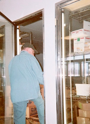 
                    A Cleveland Food Bank worker fills up the produce section.
                                            (Kaiah Callahan)
                                        