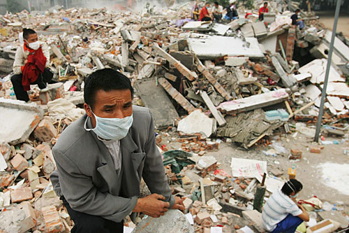 Parents of missing students of a secondary school wait outside the collapsed building as rescuers continue to dig for bodies in Hanwang, Sichuan province, China. The death toll of Monday's 7.9 earthquake is now estimated at 29,000 and is expected to rise. At least 100,000 military troops continue rescue operations in the area where tens of thousands have been made homeless.
(Andrew Wong/Getty Images)