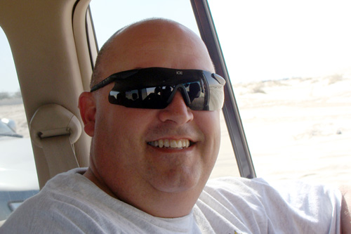 
                    Andreas Von Clausbrach rides in an SUV over sand dunes to get to a Qatari beach on the Persian Gulf for lunch and fun. He wanted to drive himself, but that's not allowed. The R&R program hires a tour company which supplies the vehicles and drivers in order to keep soldiers out of trouble, yet provide them with a good time.
                                            (Orly Halpern)
                                        
