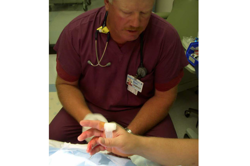 
                    Nurse Don bandages Chris's hand.  Don once saw a fisherman come in the ER with a fish hook imbedded in his nose.
                                            (Jim Gates)
                                        