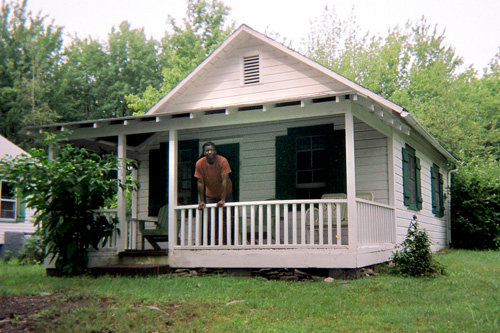 
                    The poet Cornelius Eady leans over the railing of the small house.
                                            (Sarah Micklem)
                                        