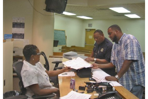 Officer Owen talks to Court Clerk Cheryl Sharpley. Joining them in plain clothes is Officer Robert Mingus, the great-grand nephew of jazz great Charles Mingus. When he's off duty, Officer Mingus teaches fathers about responsible parenthood. He worries about the effect of the foreclosure crisis on Detroit neighborhoods.
(Desiree Cooper)