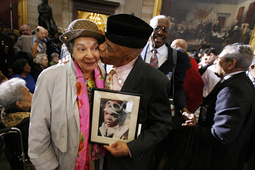 Holding a photograph of himself as a 19-year-old pilot, Tuskegee Airmen Lt. Col. John Mulzac of Brooklyn, N.Y, kisses his wife Beatrice Mulzac after a ceremony honoring the World War II in Washington, DC.
(Chip Somodevilla/Getty Images)